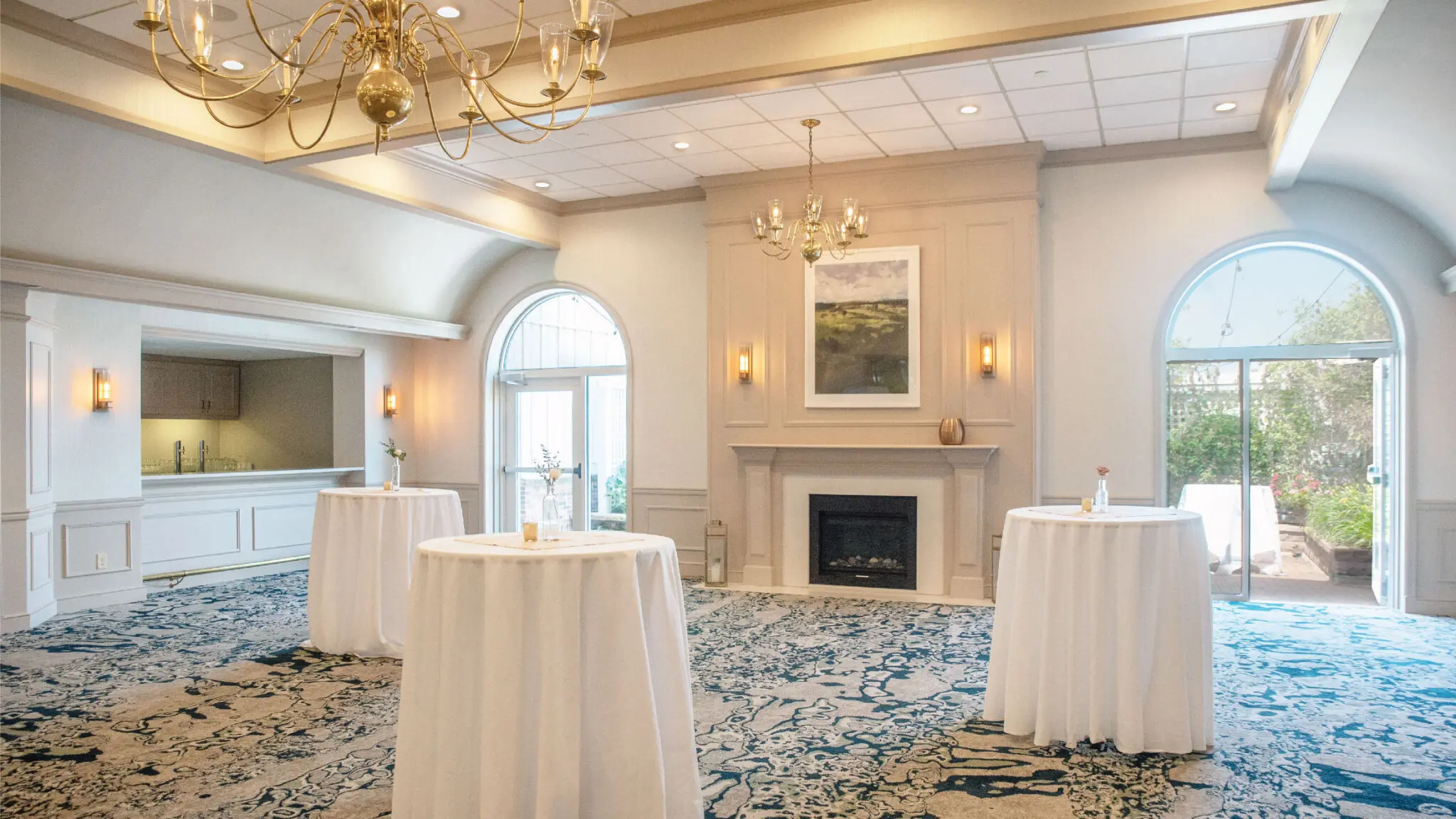 Hearthside meeting space with a built in bar and fireplace set up with cocktail rounds.