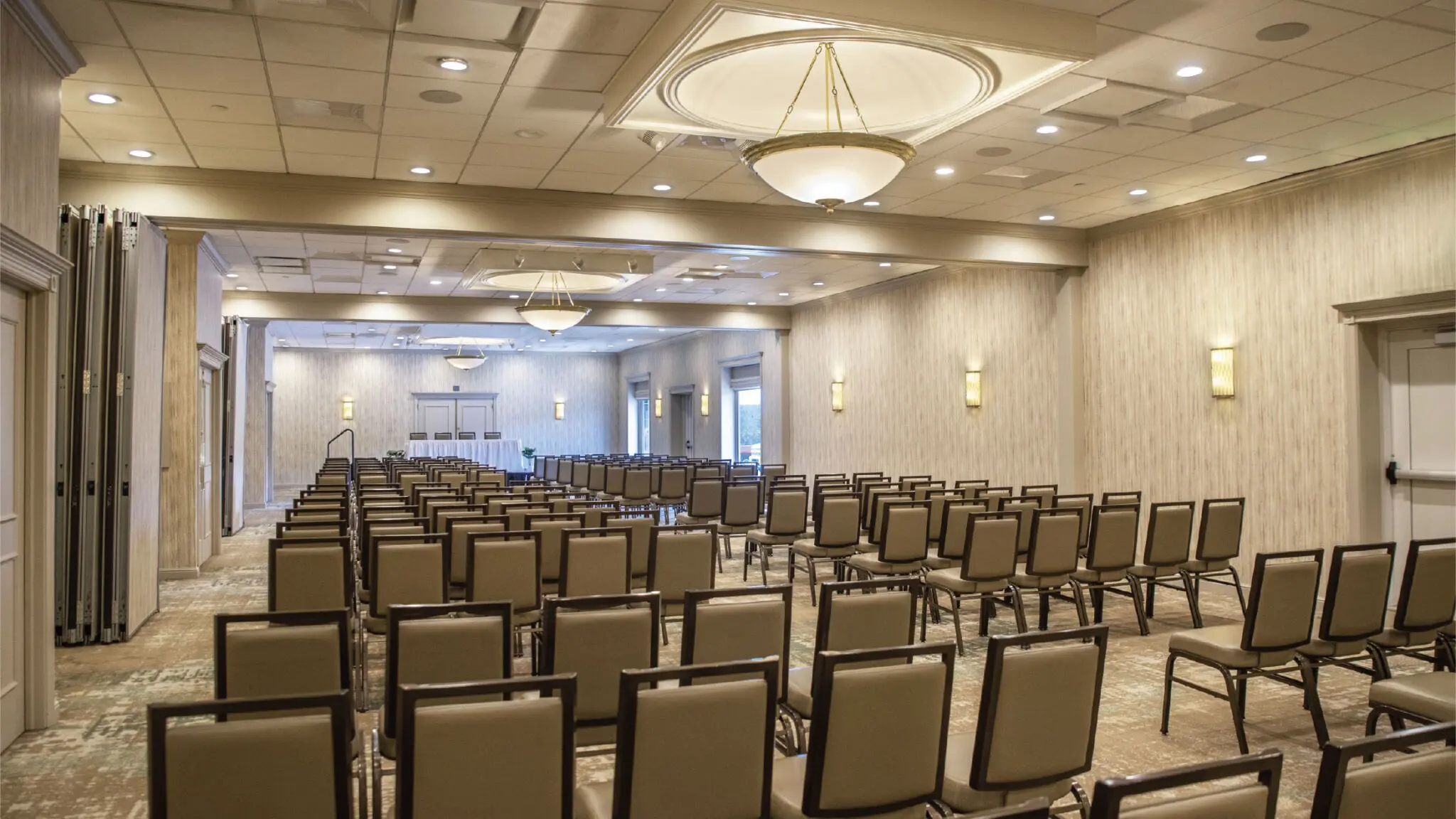 Woodland meeting space set up with rows of chairs and a stage.