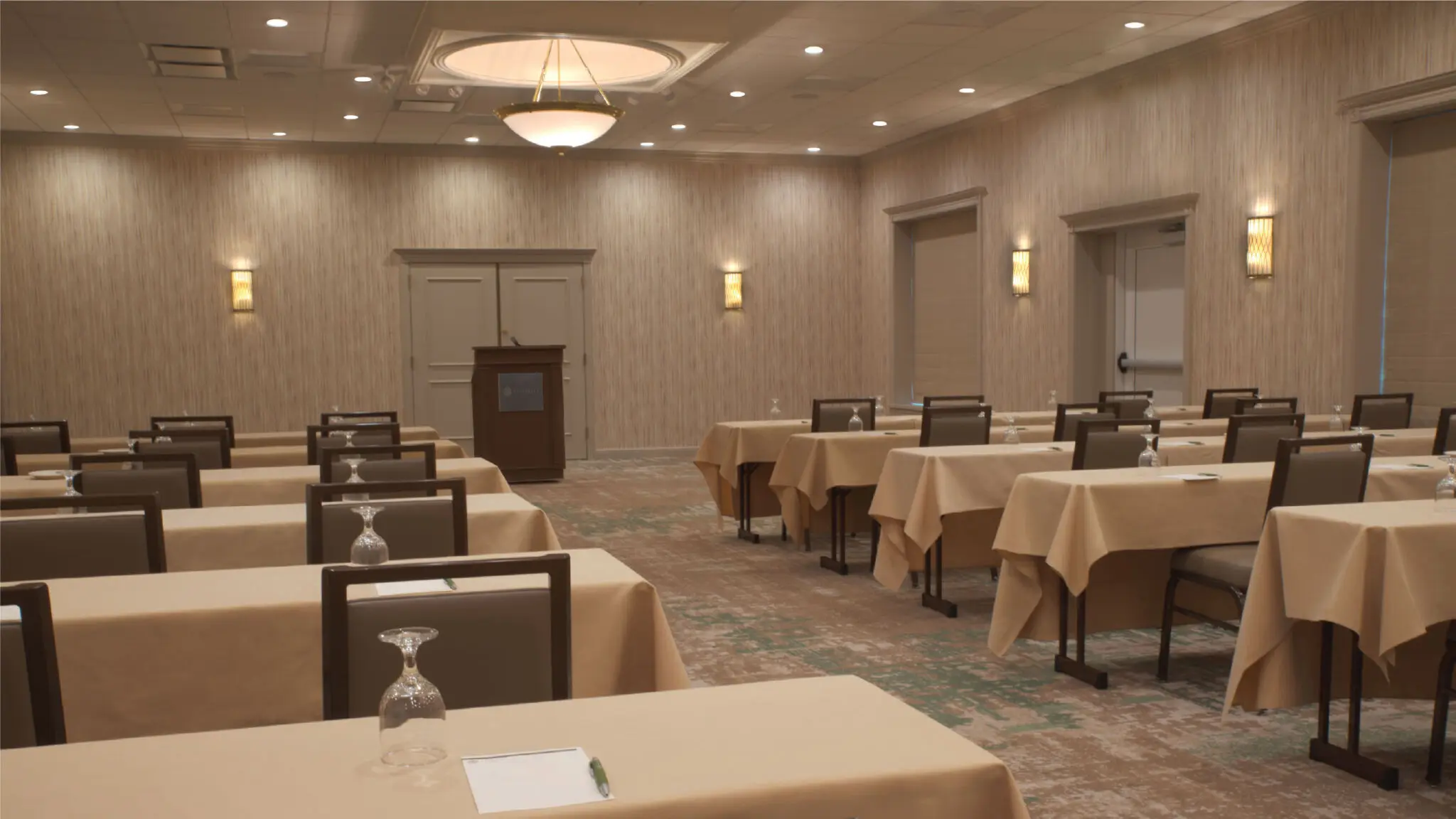 Woodland meeting space set up with rectangular tables and podium.