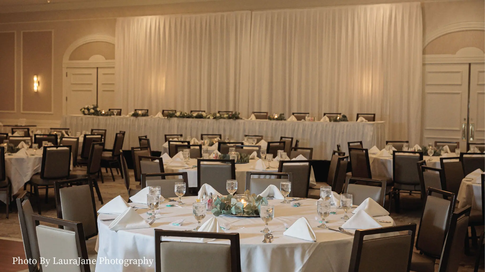 Oakton ballroom wedding receptions with round table and a head table on a stage.