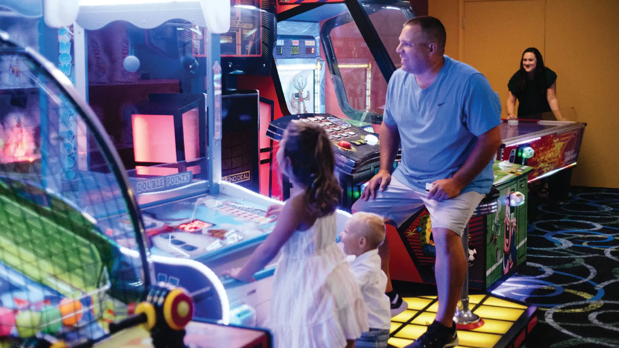 Families enjoying playing games in an arcade.